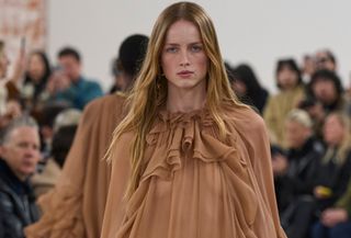 Chloe model wearing a tan sheer ruffled dress at the F/W 24 show.