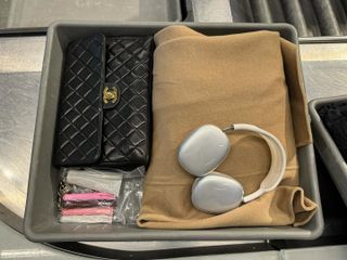 a Chanel flap bag, Rhode lip gloss, and AirPods Max on a plane