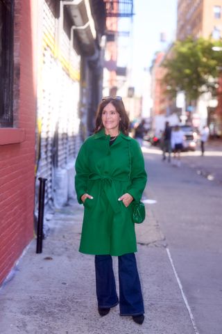 A Nordstrom buyer wearing a green wool coat with flared jeans.