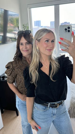 A Nordstrom buyer posing with her daughter wearing an animal print blouse with jeans.