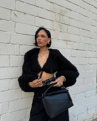 Nara Smith taking a photo outside in front of a white wall