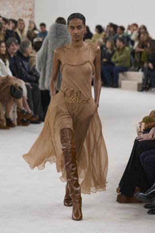 Woman in sheer dress and over-the-knee boots.