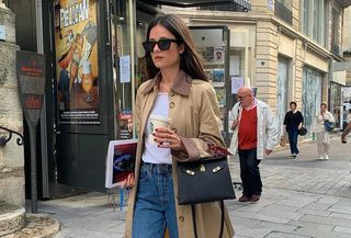 French influencer @leasy_inparis wearing a tan canvas jacket, a white T-shirt, blue jeans, and Hermès handbag in Paris.