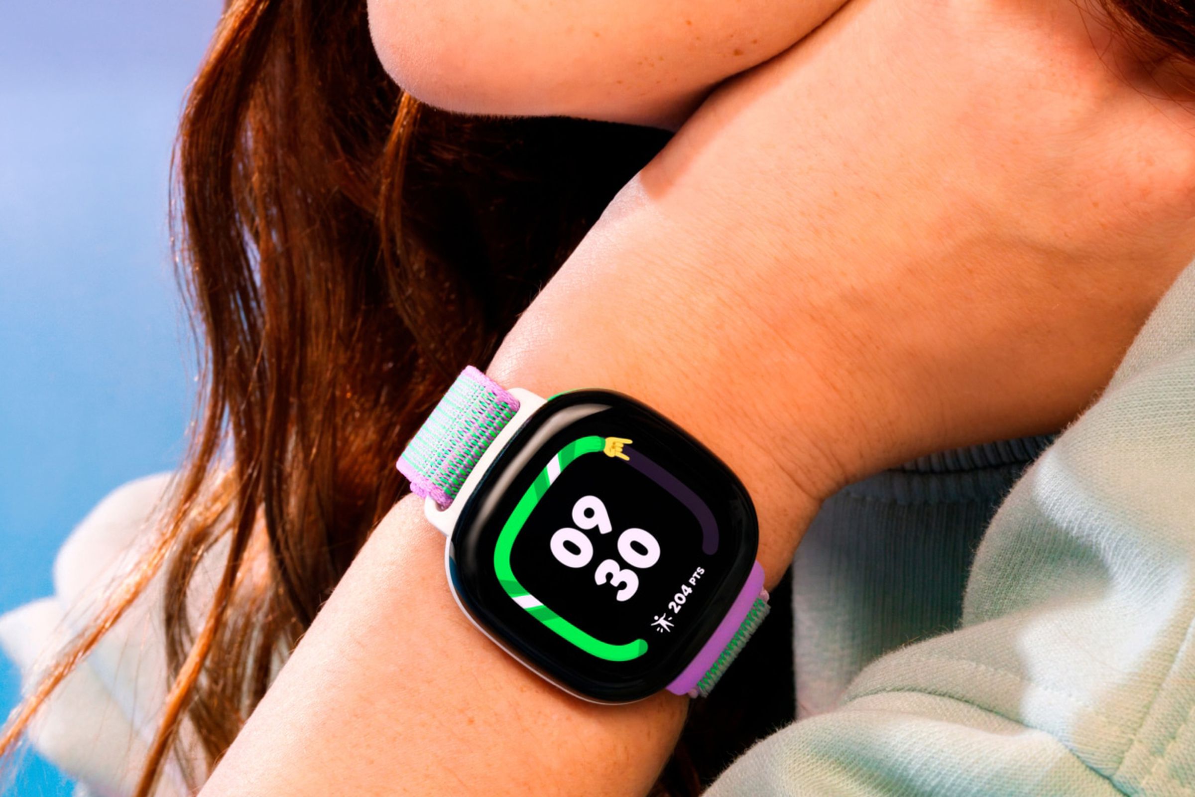 A close-up image of a teenage girl wearing the Fitbit Ace LTE on her wrist.