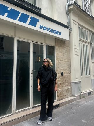 Eliza Huber wearing a black sporty Proenza Schouler jacket with a red tank top, black poplin pants, and gray New Balance sneakers in Paris.