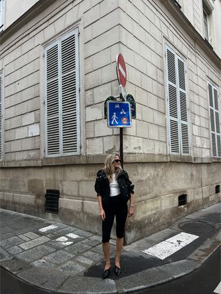 Eliza Huber wearing a black sporty Proenza Schouler jacket with a white tank top, black capris, and black Prada heels in Paris.