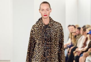 Model at Michael Kors Fall/Winter 2024 wearing leopard print coat.