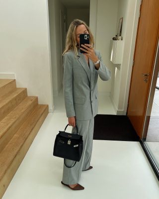 Woman wearing a heather gray suit.