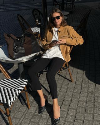 French fashion influencer Anne-Laure Mais wearing a chic fall outfit with black pants in Paris.