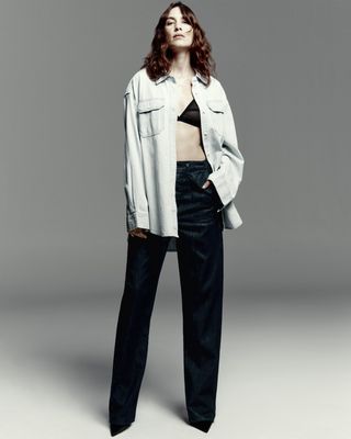 Photo of Alexa Chung for Madewell Collaboration campaign, wearing jeans, black bra, and button-down denim shirt.