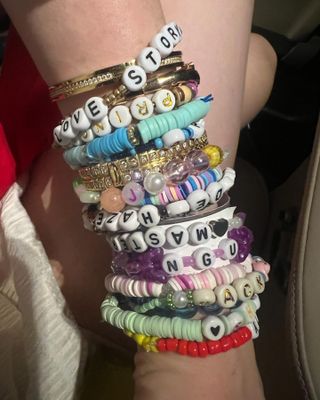 A wrist with a lot of friendship bracelets on it at the Taylor Swift concert.