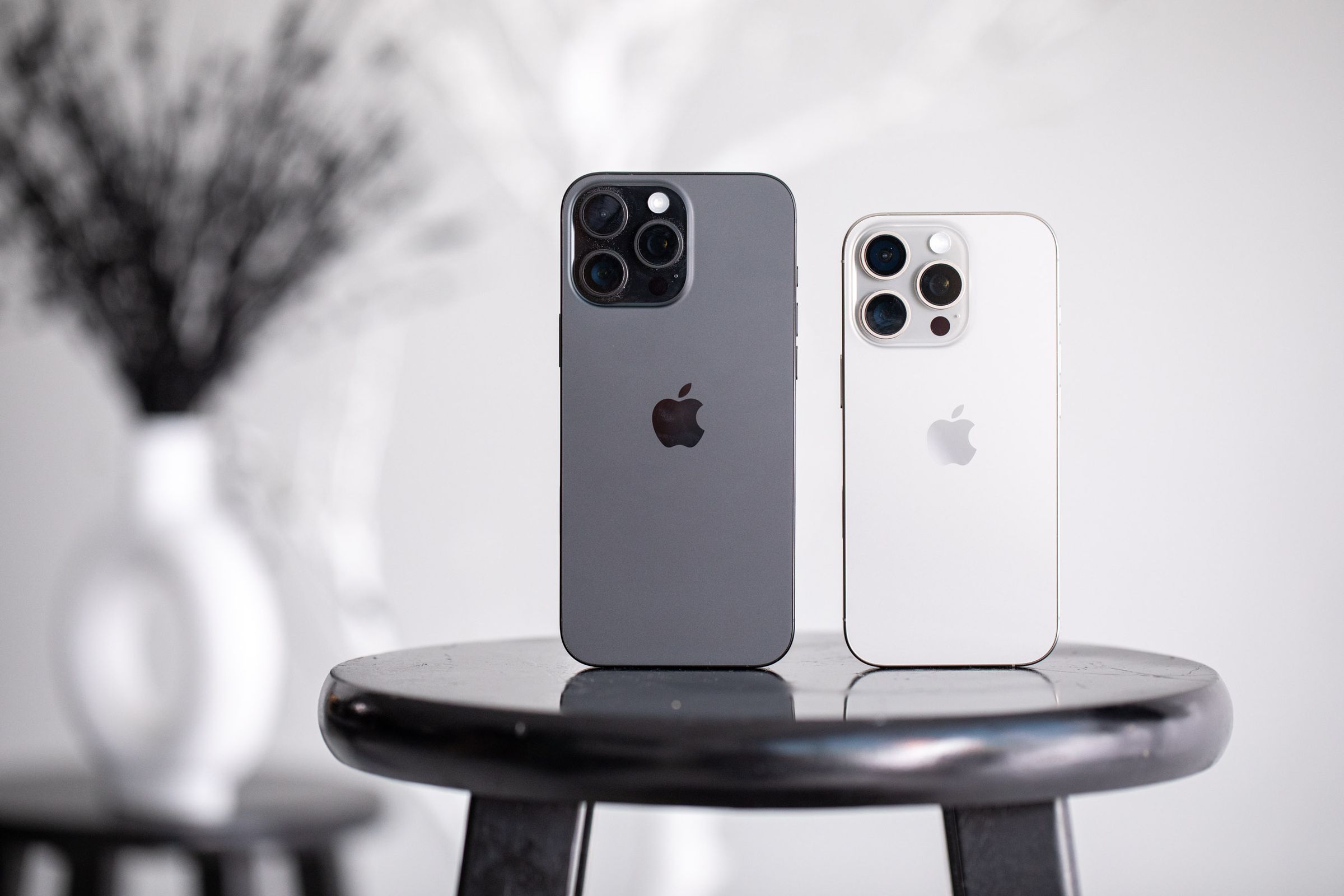 The iPhone 16 Pro and 16 Pro Max on a stool.