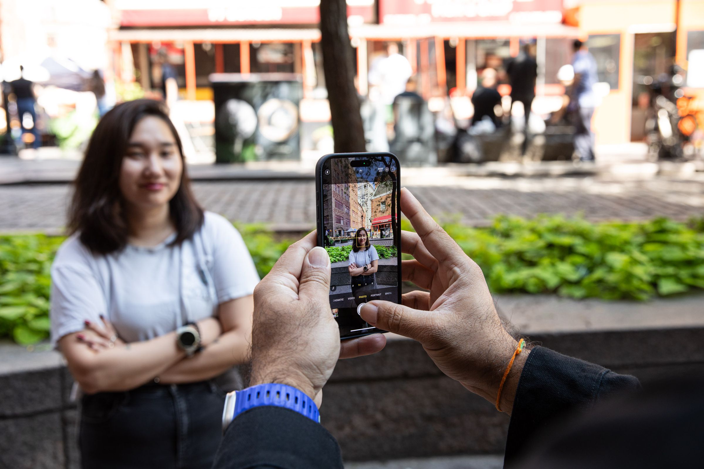 The iPhone 16 Pro Max being used to take a photo of a person.