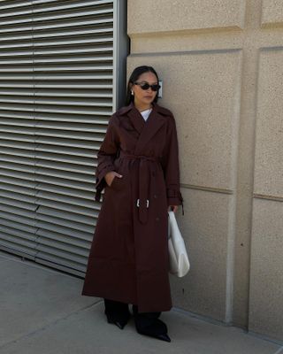 Influencer wears a burgundy trench coat.