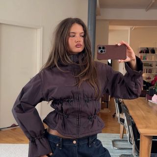 Influencer wears a plum jacket.