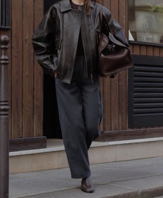 A fashion person wearing an oversize leather jacket.