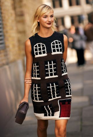 a street style photo of a woman wearing a printed knit mini dress to JW Anderson's spring 2025 runway show