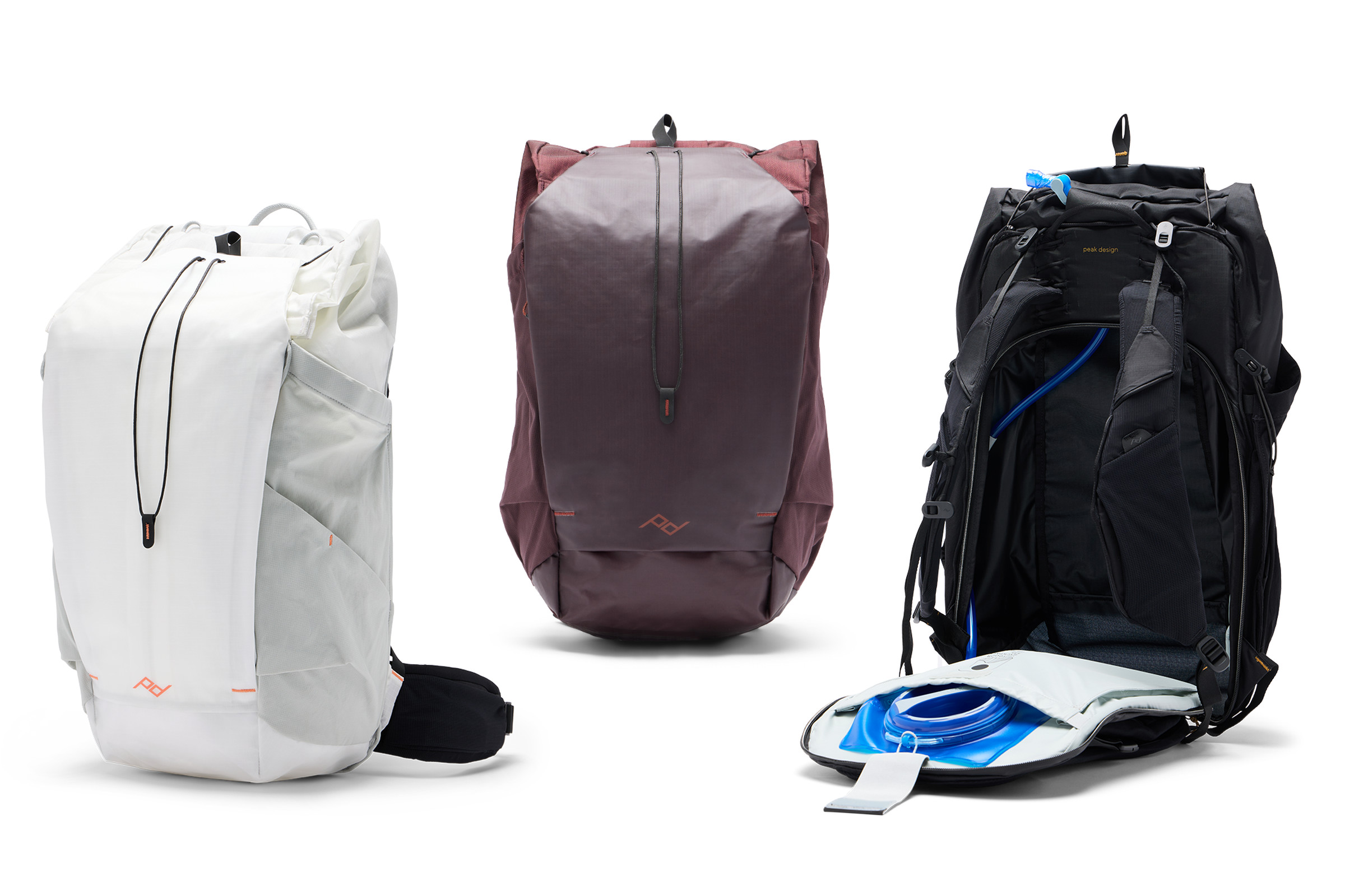 Three backpacks are shown in white, black, and deep purple from front, side, and back with the back panel unzipped to show how the bag stores a hydration pouch and hose.