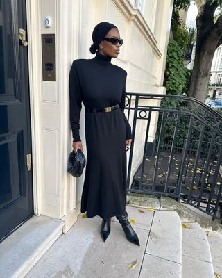 @nlmarilyn wearing a black dress and pointed-toe boots