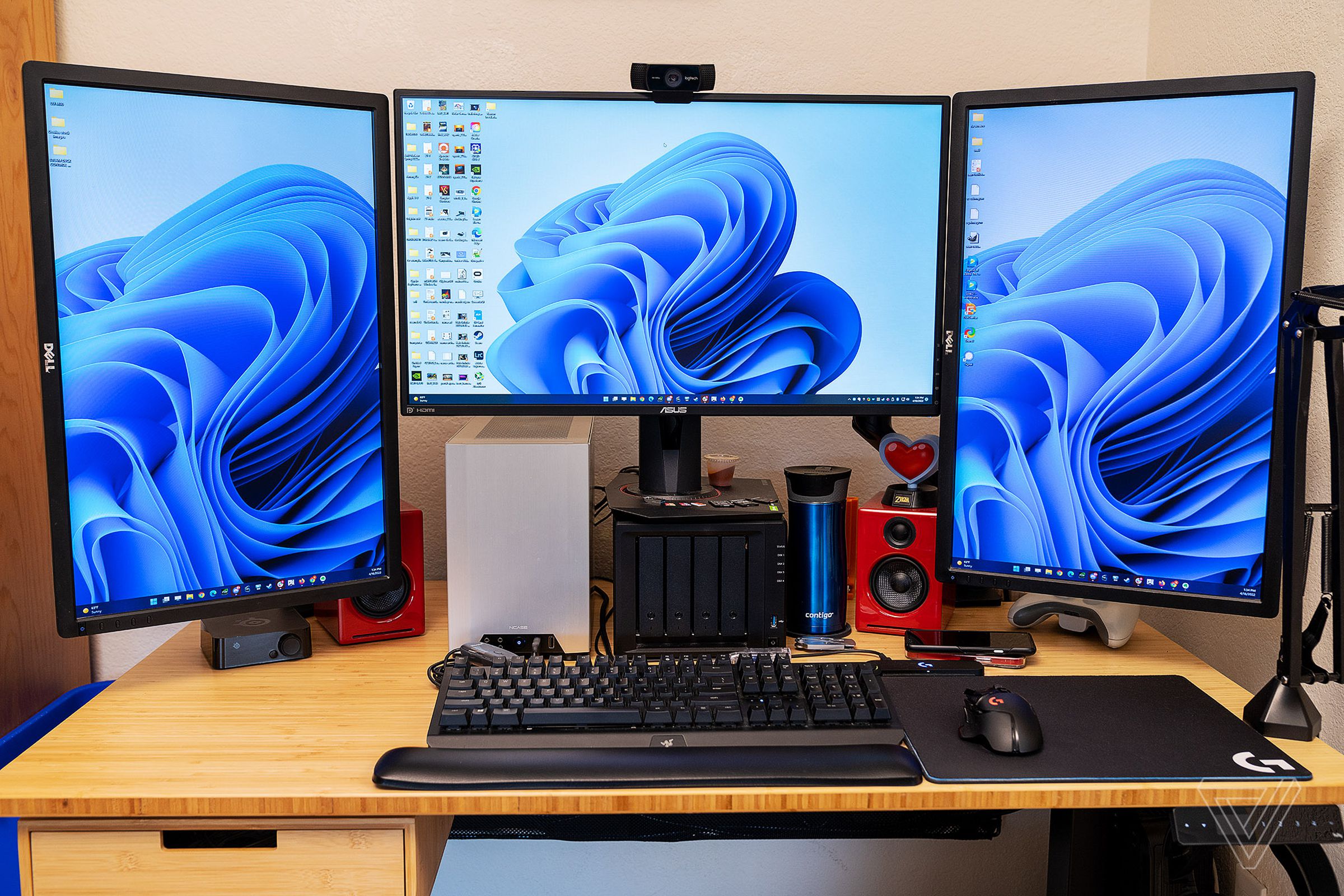 Three monitors sit atop a Fully Jarvis Bamboo Standing Desk.