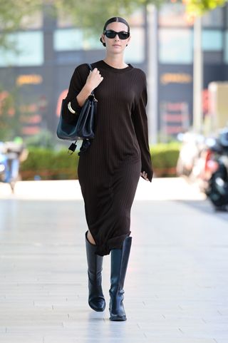 Vittoria Ceretti wears a sweater dress and boots while off-duty during Milan Fashion Week