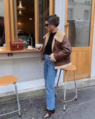 Influencer wears an aviator jacket.