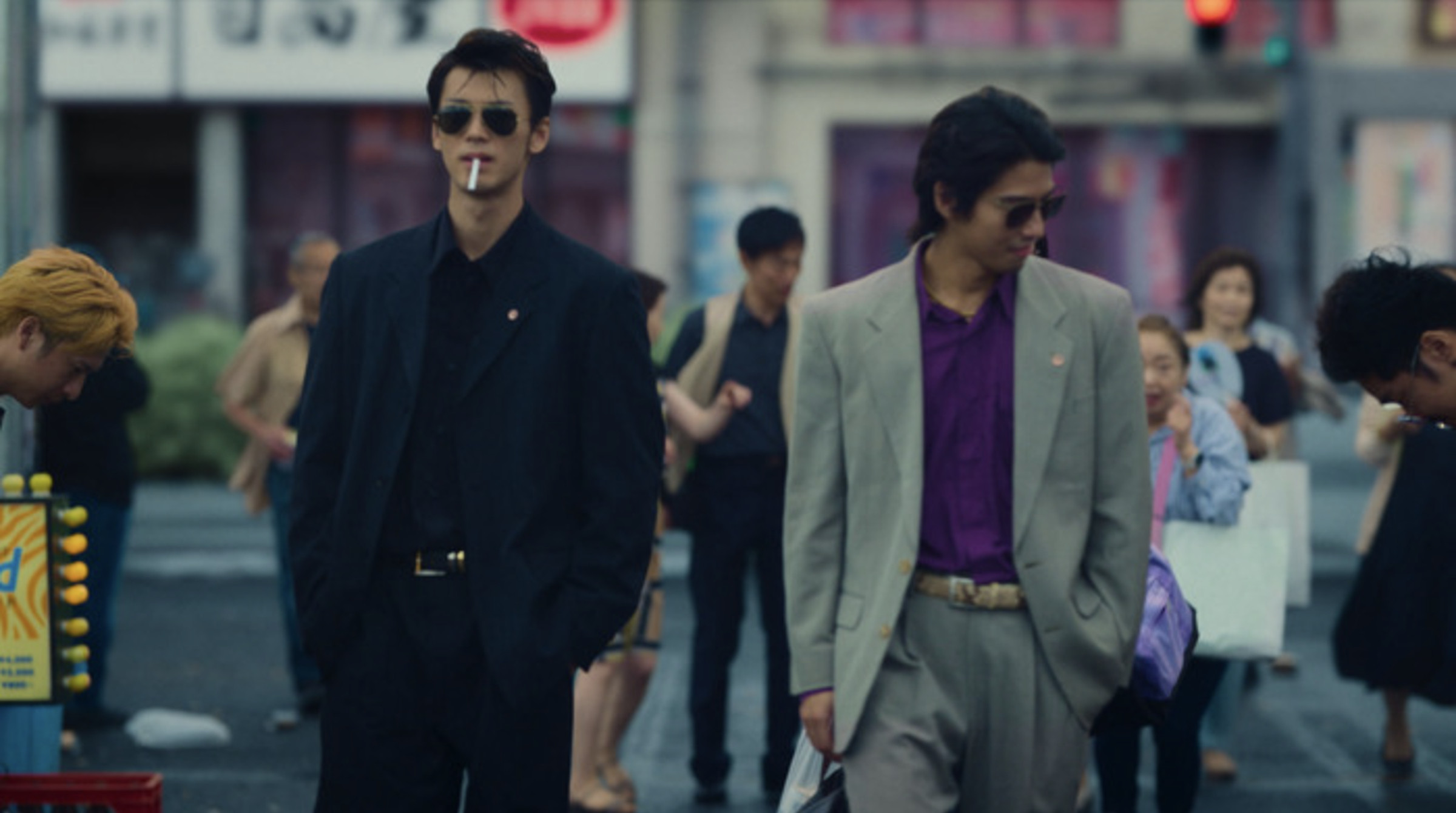 Screenshot from Like A Dragon Yakuza featuring two Japanese men walking through the Kamurocho district of Tokyo.