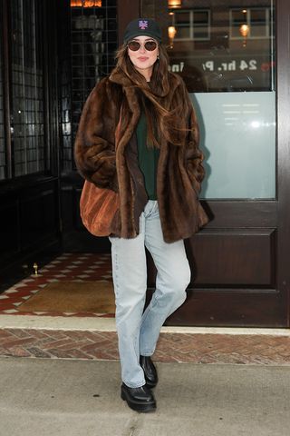 Dakota Johnson wearing a faux fur coat and jeans