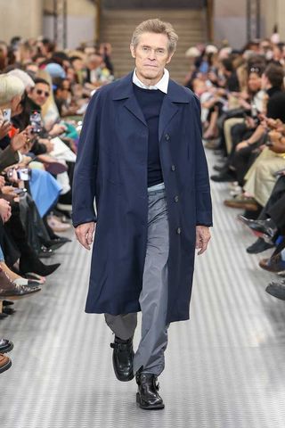 Willem Dafoe walking the runway at Miu Miu's Spring/Summer 2025 Paris Fashion Week show.