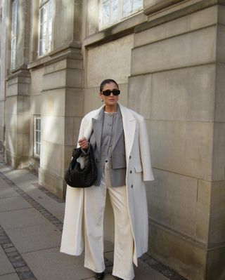 woman wearing a white coat and jeans and gray blazer in Copenhagen