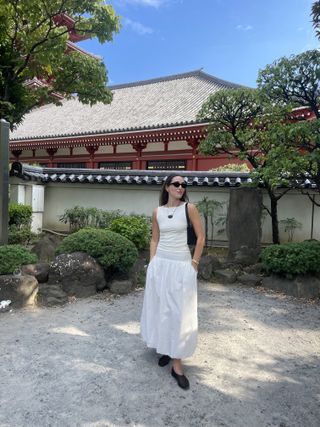 Anna LaPlaca wearing a white Reformation Dusk top and white bubble-hem maxi skirt in Japan