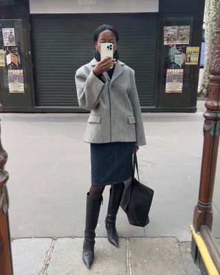 Influencer wears a skirt and knee boots.