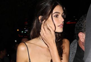 Kaia Gerber is seen leaving the Chateau Marmont Hotel after attending an after-party for the 2024 Academy Museum Gala in Los Angeles wearing a black spaghetti strap knee-length dress and matching accessories.