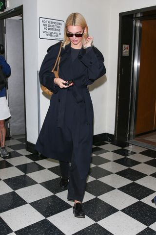 Kendall Jenner wears a navy trench coat.