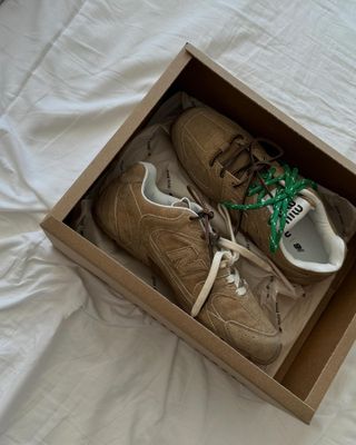 Miu Miu x New Balance sneakers in a box.