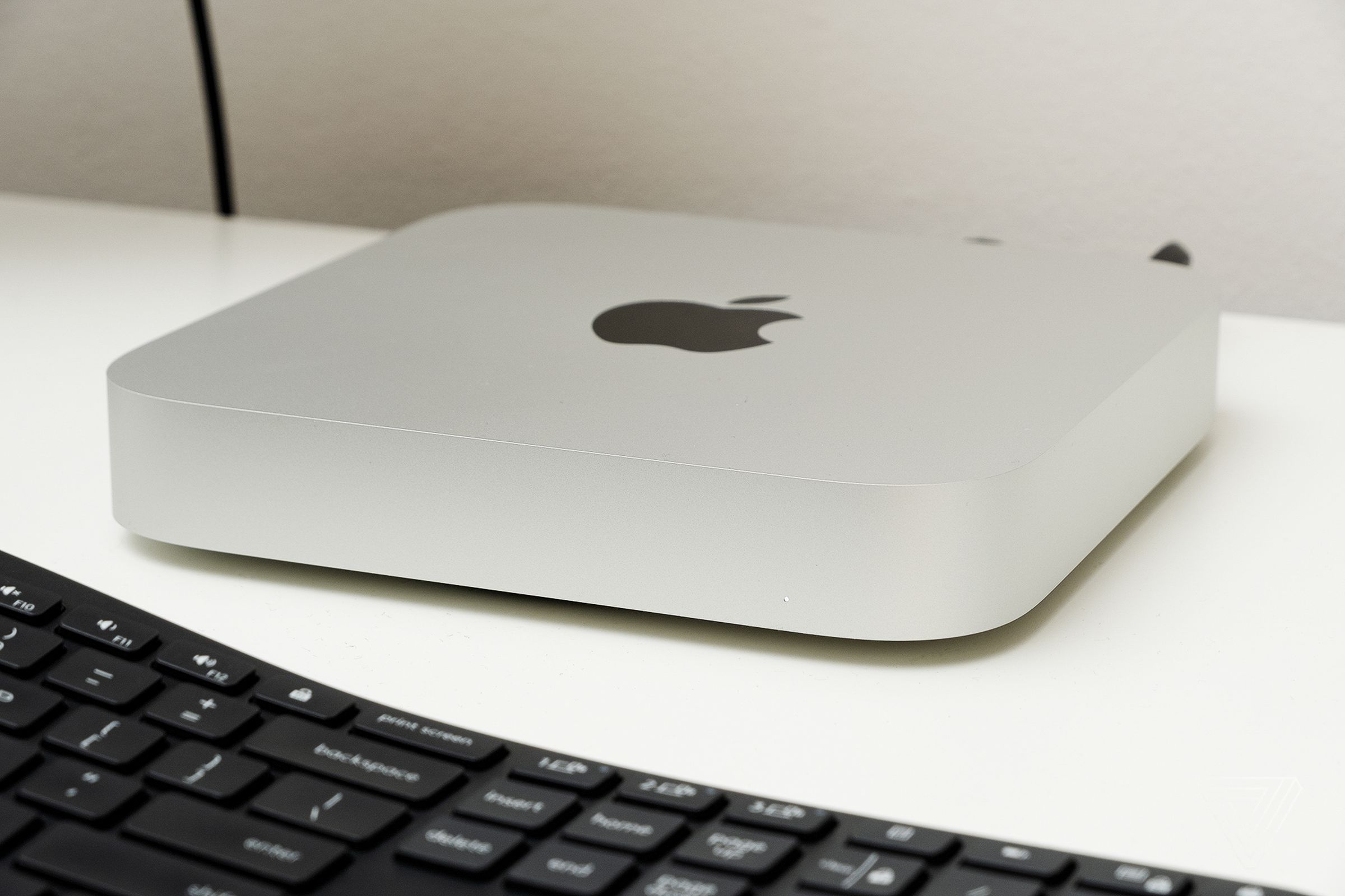 Picture of a Mac Mini sitting on a desk with a keyboard in front of it.