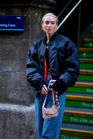 Influencer wears black leather bomber jackets with jeans.