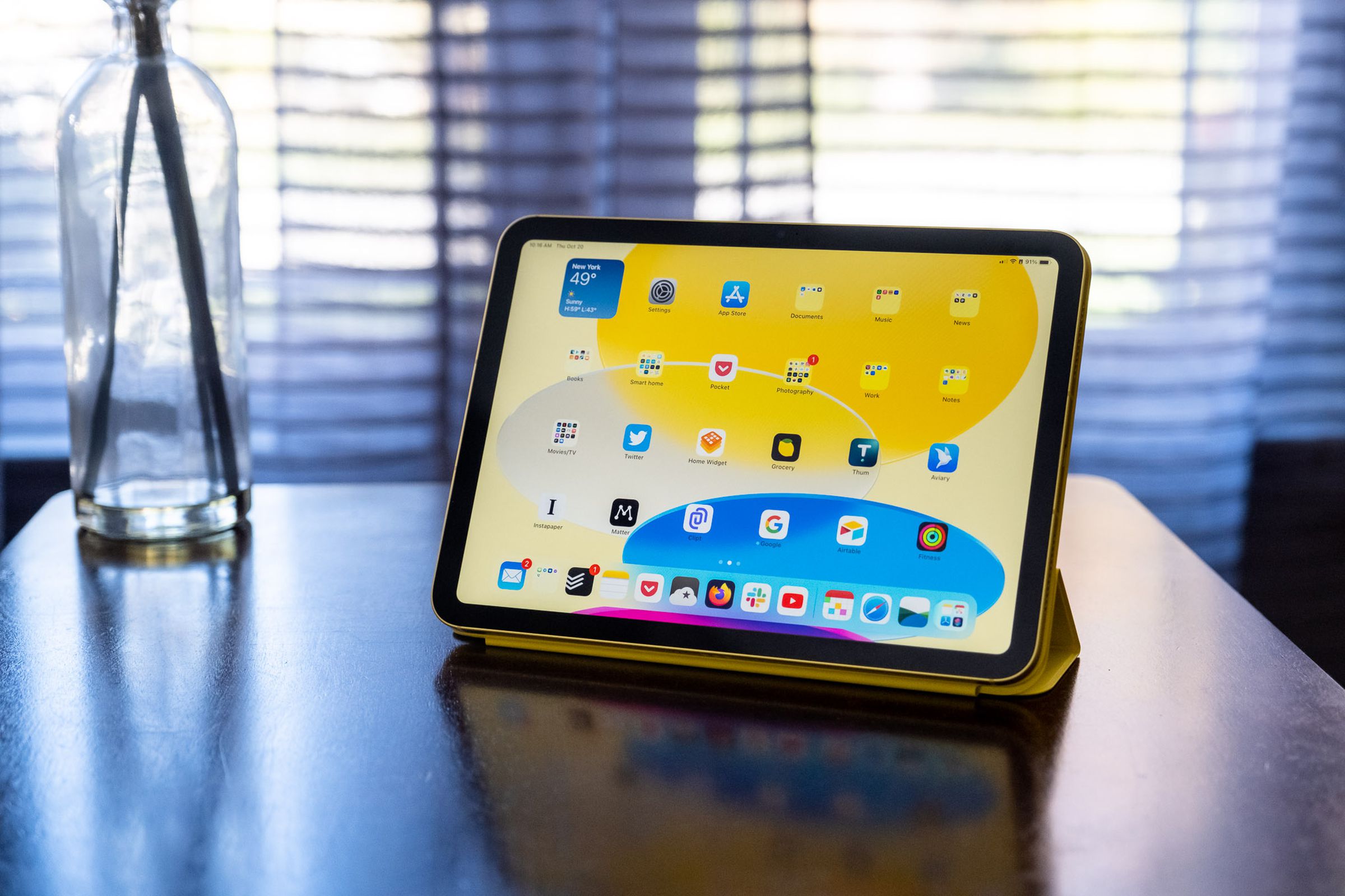 A 10th-gen iPad in an Apple Smart Folio on a wood table.