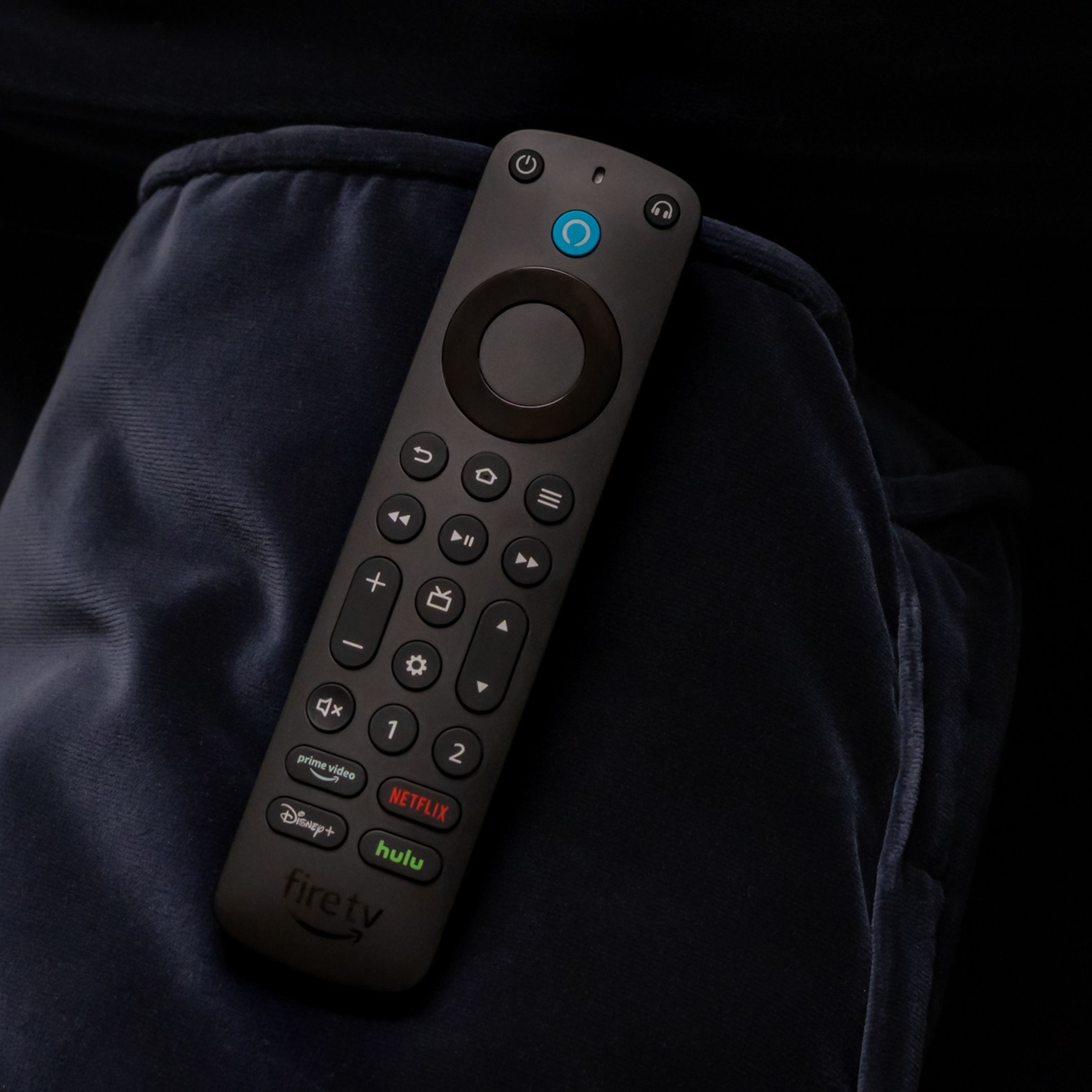 A photo of the Amazon Alexa Voice Remote Pro on a couch arm.