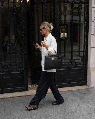 @clairerose wearing a white button-down shirt with silk pants and Alaia fishnet flats