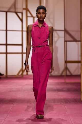 an Hermes model walks the spring/summer 2025 runway in a fuchsia pink look