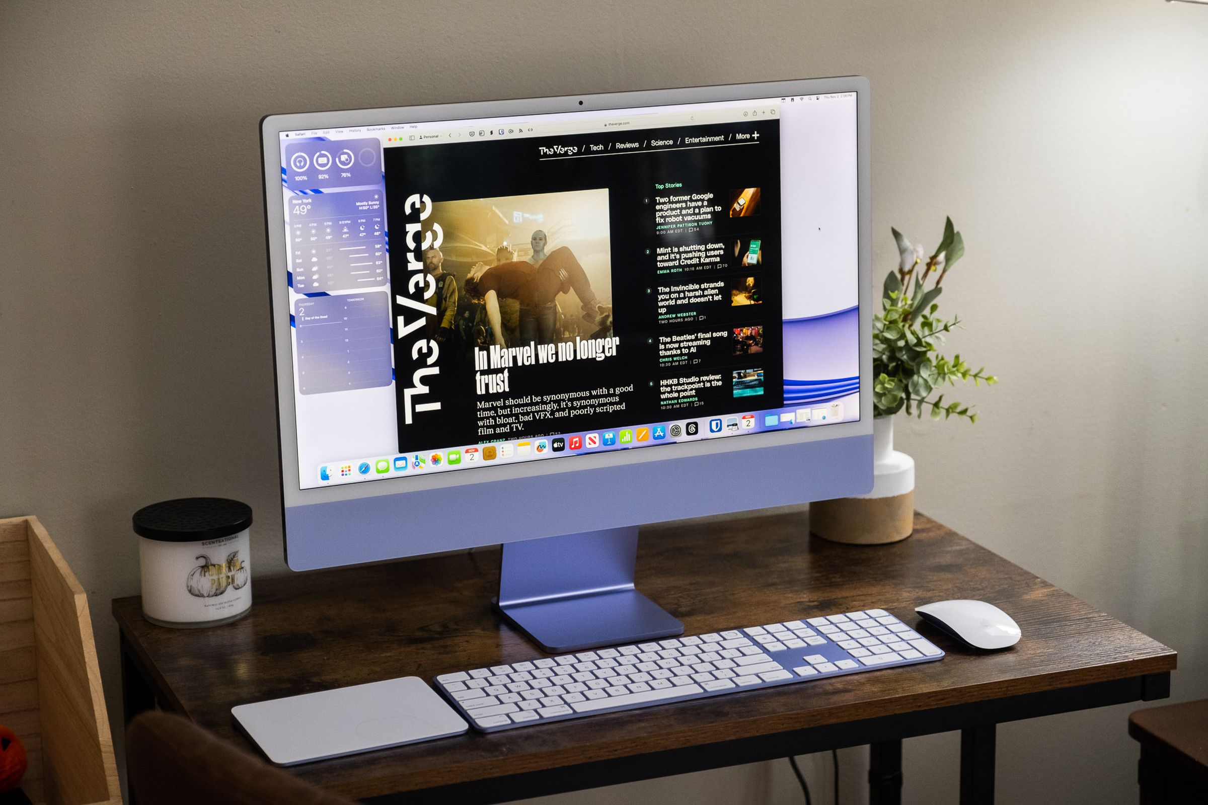 A purple iMac on a wooden desk