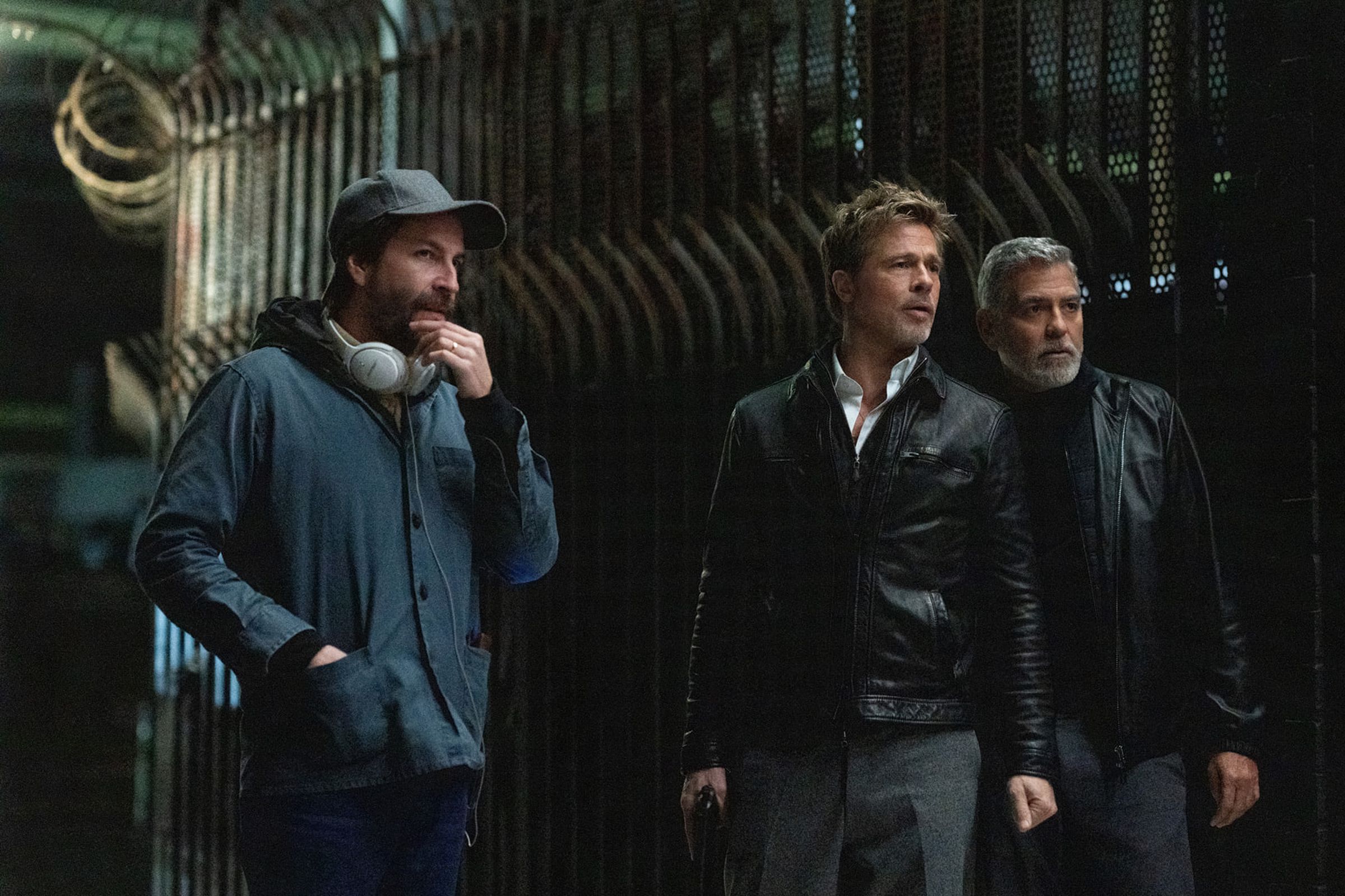 Picture of director Jon Watts (left) standing with actors Brad Pitt (middle) and George Clooney (right) on the set of Wolfs.