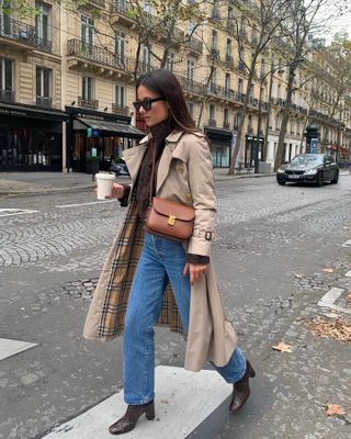 Woman in trench coat and brown boots.