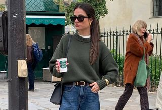 Woman in olive green sweater and jeans.