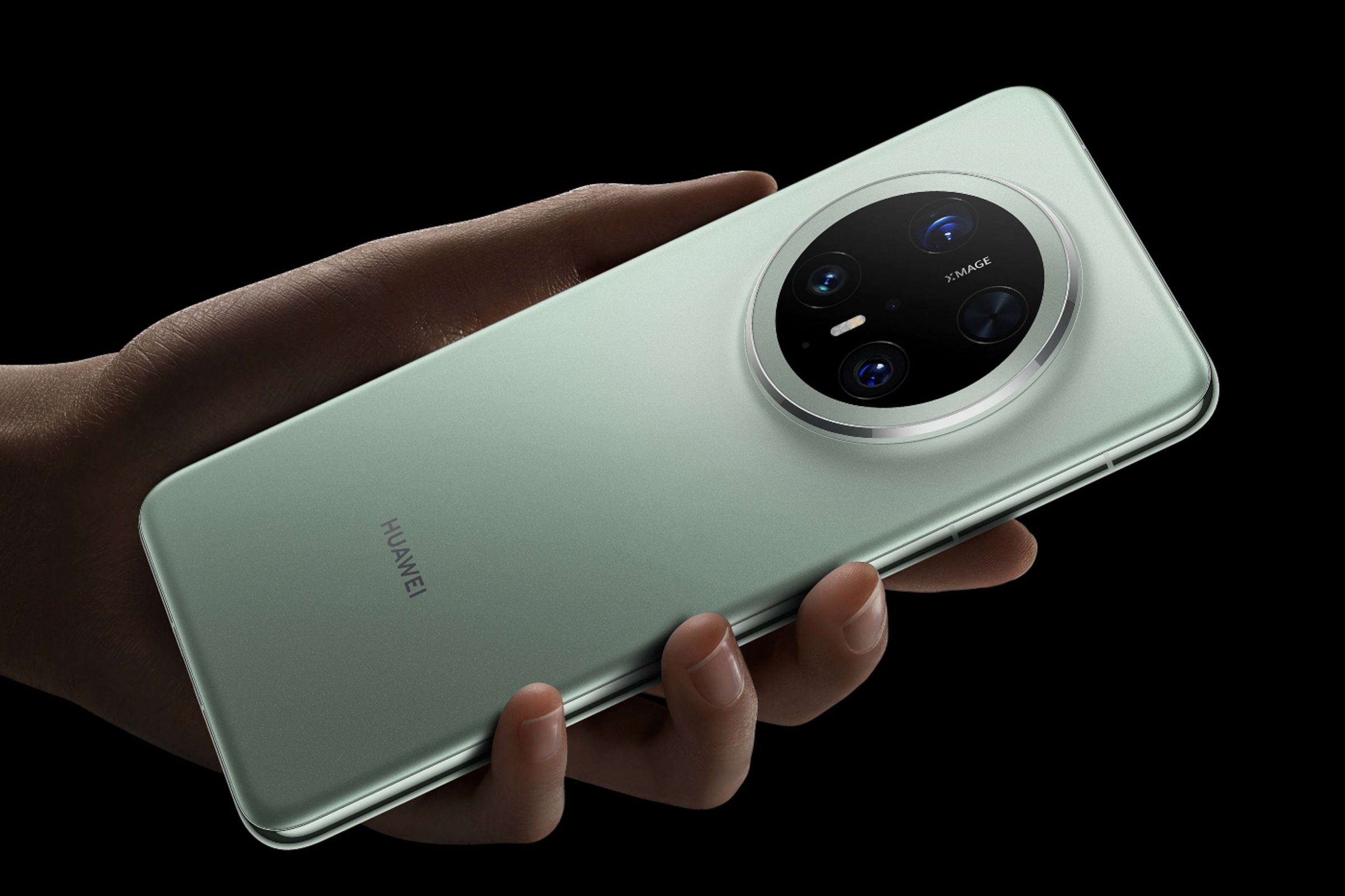 A hand holding the Huawei Mate 70 Pro smartphone featuring a green finish.