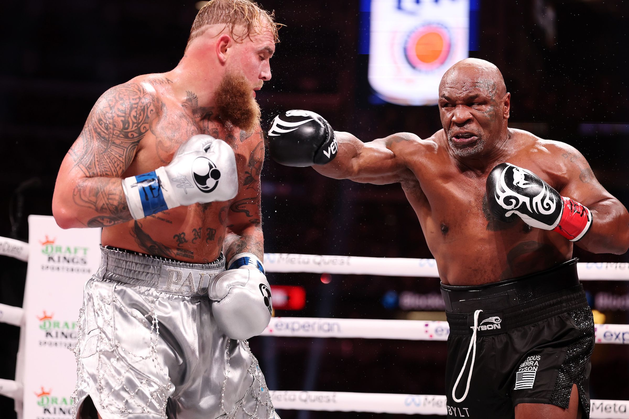 Image showing Mike Tyson, mid-punch as Jake Paul dodges.