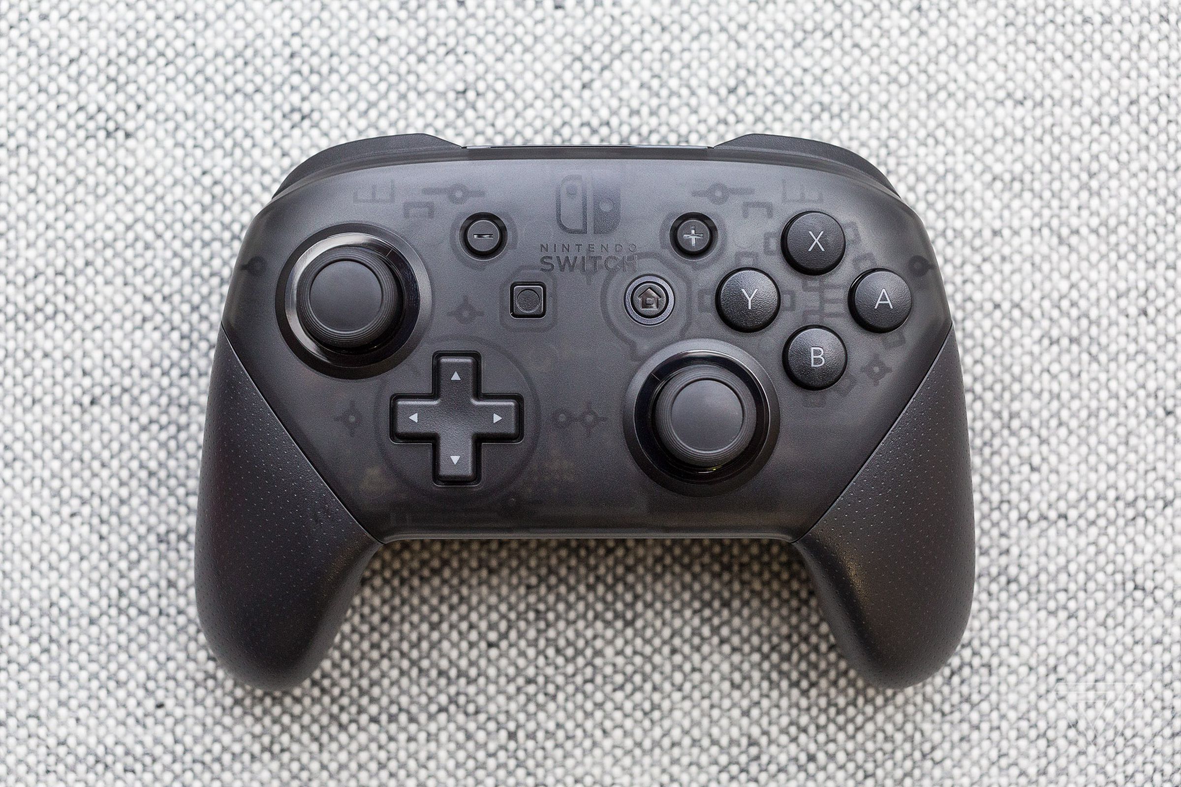 A Nintendo Switch Pro controller on a textured surface.