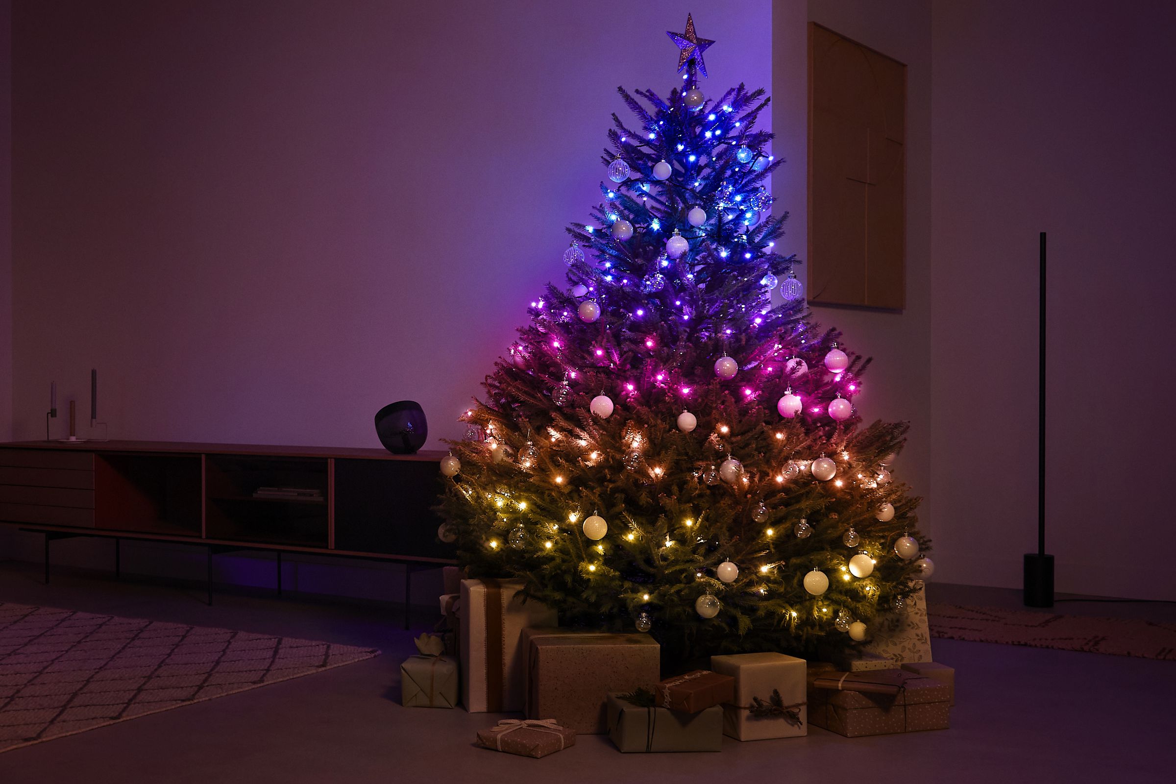 A tree decorated with Philips Hue’s Festavia smart string lights in a dark room.