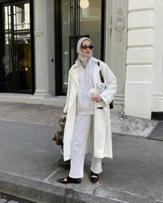 Influencer wearing a coat, Aritzia sweatsuit, and pointed-toe flats